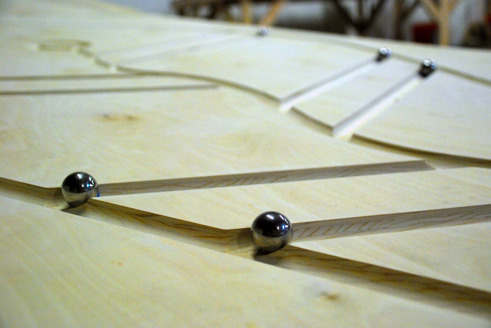 Image of a board from the OK Go video with several ball bearings rolling down it